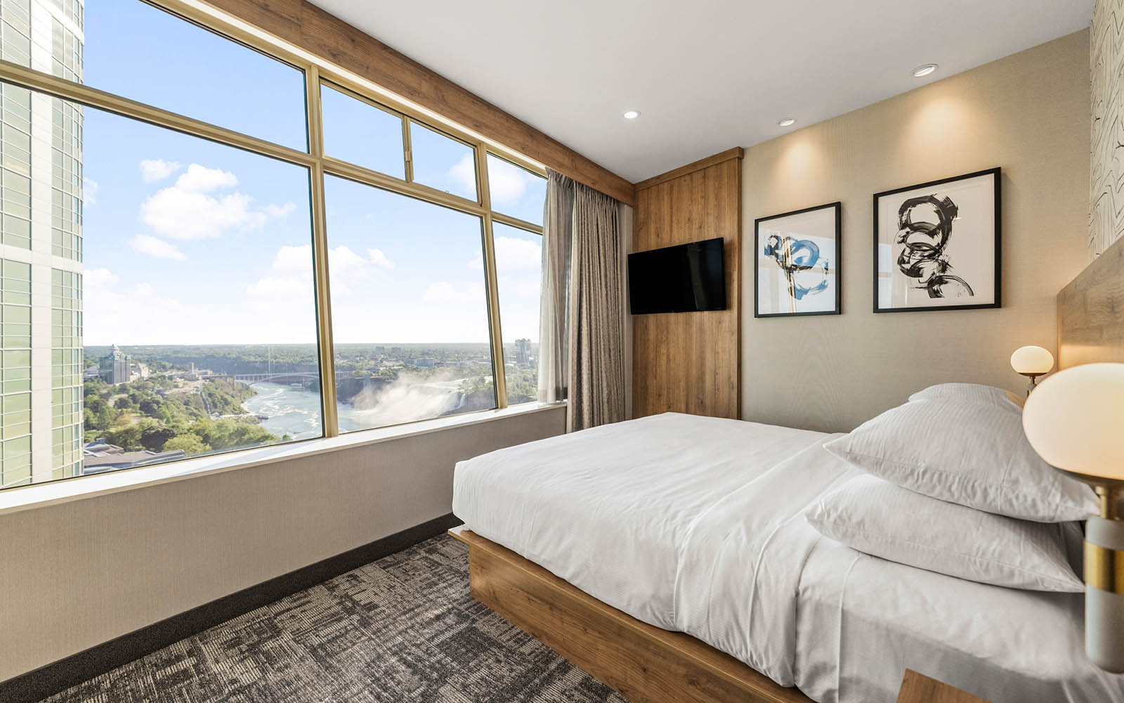 A hotel room with a king bed and a spacious desk for work or study purposes.