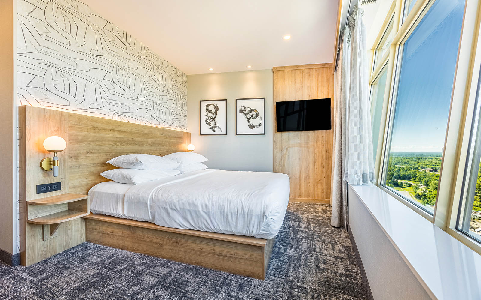 A hotel room with a king bed and a spacious desk for work or study purposes.